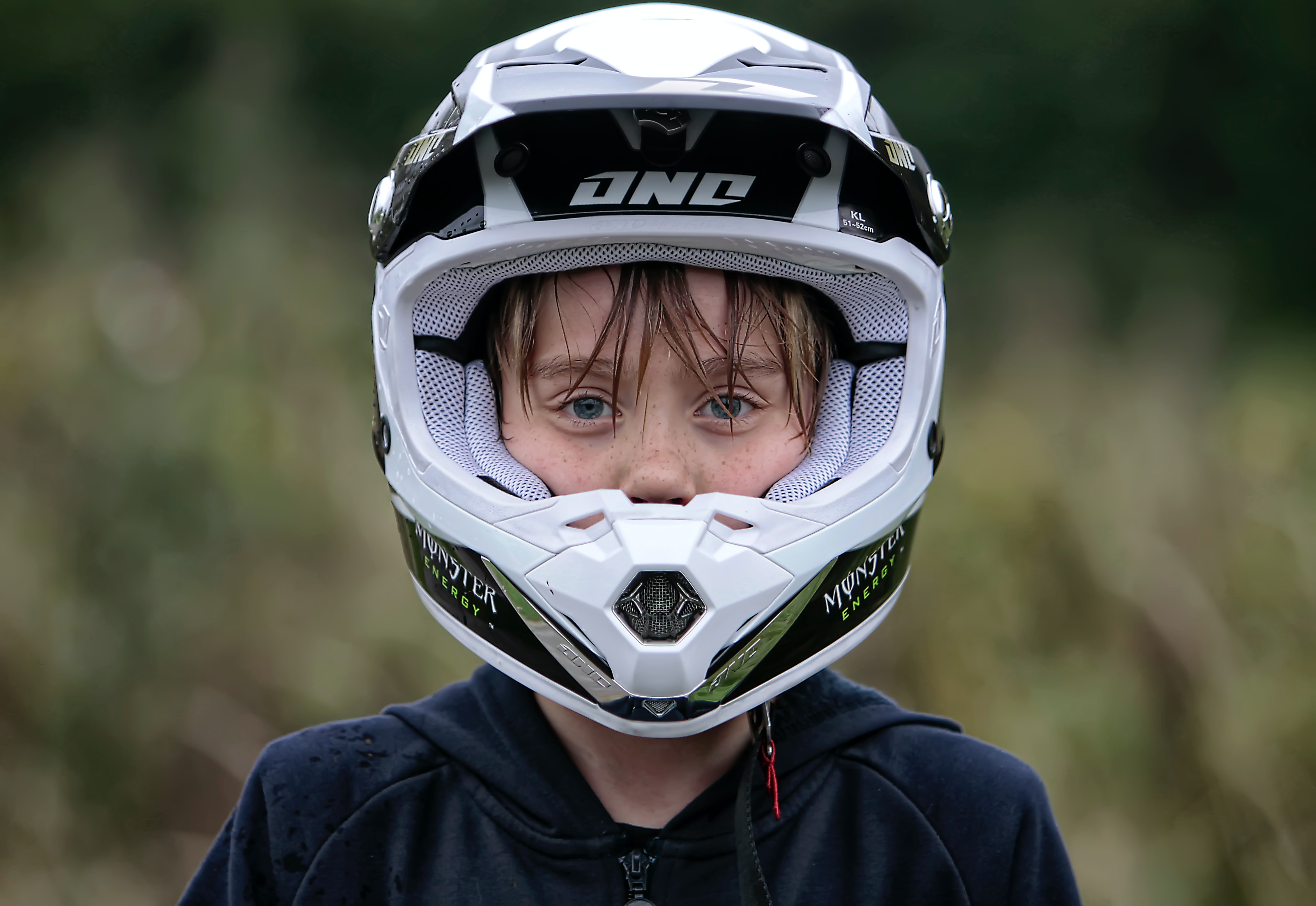 woman in a blue jacket wearing a white motorcycle helmet