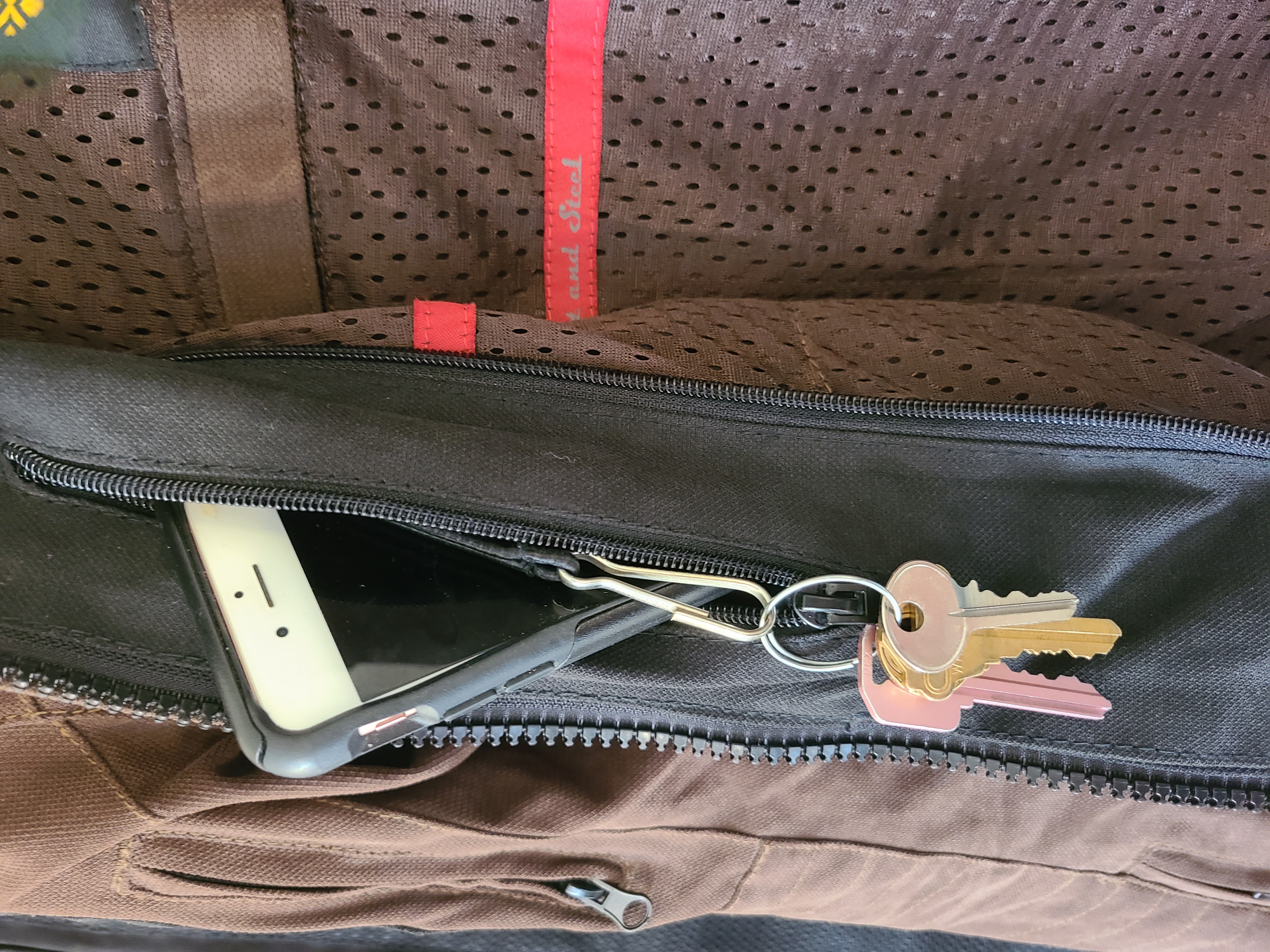 interior pocket of a brown jacket with phone and keyring